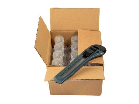 The cardboard box is opened with a knife. Stock Photos