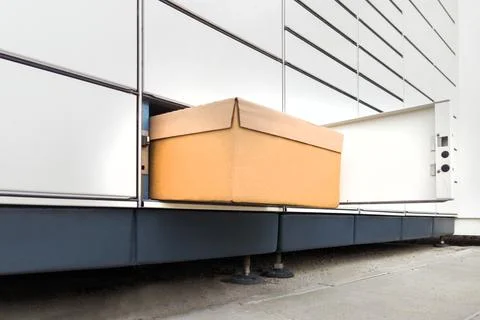 Cardboard Box Partially Pulled from Parcel Locker Stock Photos