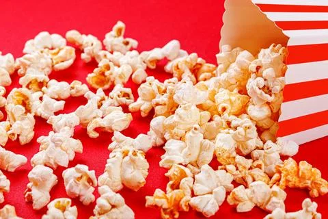 Cardboard box with popcorn on a red background Stock Photos
