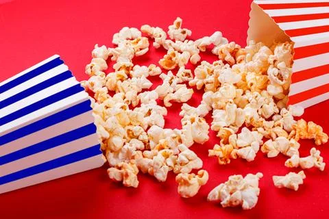 Cardboard box with popcorn on a red background Stock Photos