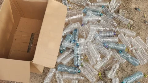 Cardboard box with scattered plastic bottles on ground. Recycling concept. Stock Footage 346243765