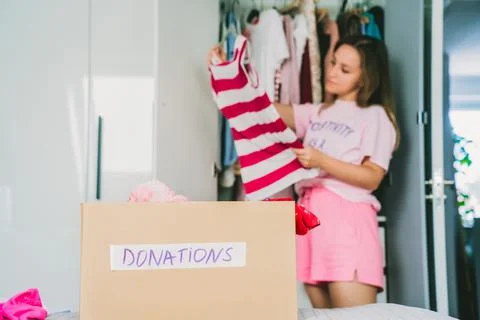 A cardboard box of selected clothes for donating to a Charity shop standing on Stock Photos