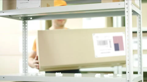 Cardboard box from the United States of America and warehouse worker Stock Footage