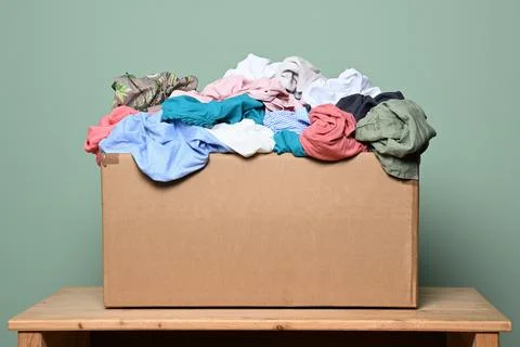 Cardboard box with various clothes Stock Photos