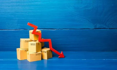 Cardboard boxes and red down arrow. Fall in sales and production of goods, .. Stock Photos