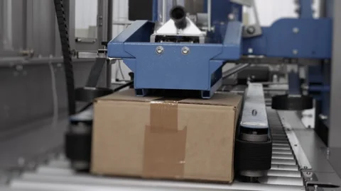 Cardboard boxes are sealed with tape on the production line. Stock Footage 306575933