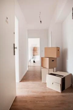 Cardboard boxes on corridor while man walking in background Stock Photos