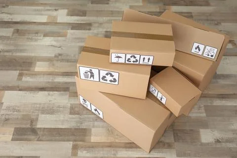 Cardboard boxes with different packaging symbols on floor. Parcel delivery Foto stock