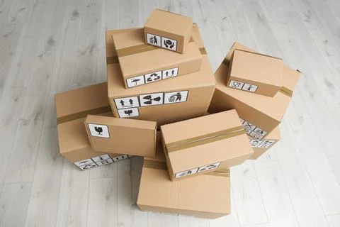 Cardboard boxes with different packaging symbols on floor, above view. Parcel Foto stock