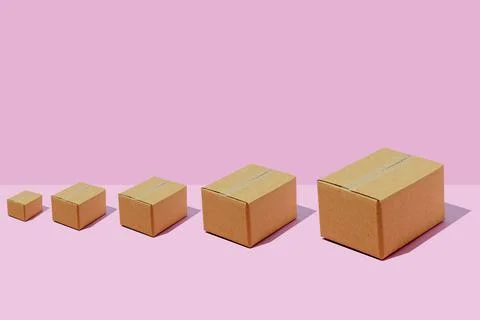 Cardboard boxes of different sizes in a row on a purple background. Parcel de Stock Photos