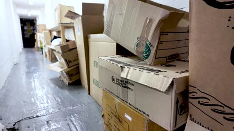 Cardboard boxes piling up along a neglected and messy office building hallway Stock Footage 331031284