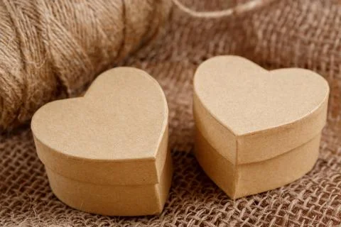 Cardboard boxes in the shape of a heart on the canvas on a wooden background Stock Photos