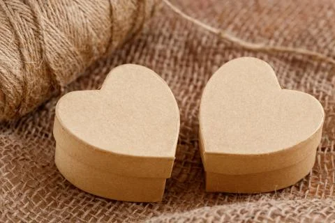 Cardboard boxes in the shape of a heart on the canvas on a wooden background Stock Photos