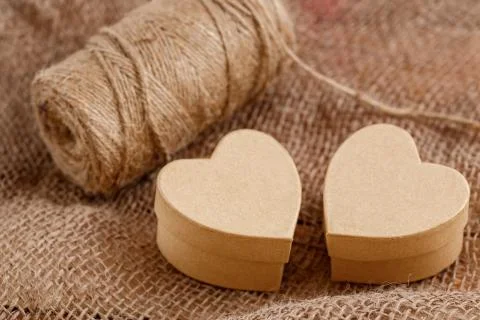 Cardboard boxes in the shape of a heart on the canvas on a wooden background Stock Photos