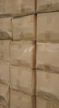 Cardboard boxes stacked inside warehouse behind reflection window close up Stock Photos