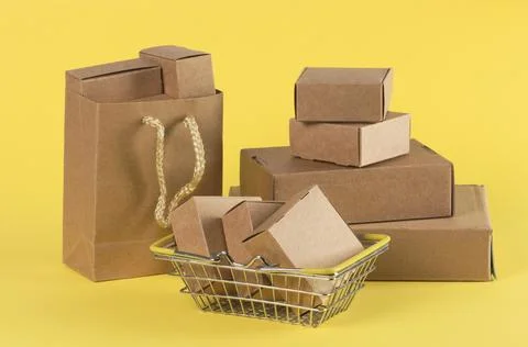 Cardboard boxes of various sizes, baskets, and bags on a yellow background. Stock Photos