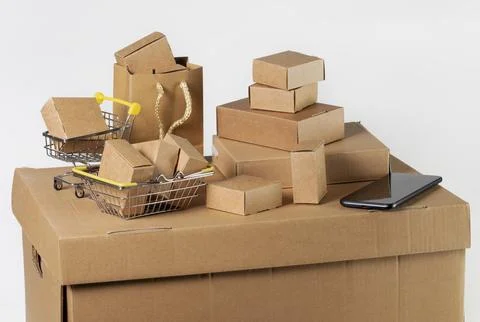 Cardboard boxes of various sizes, baskets, bags, and a smartphone on a whit.. Stock Photos
