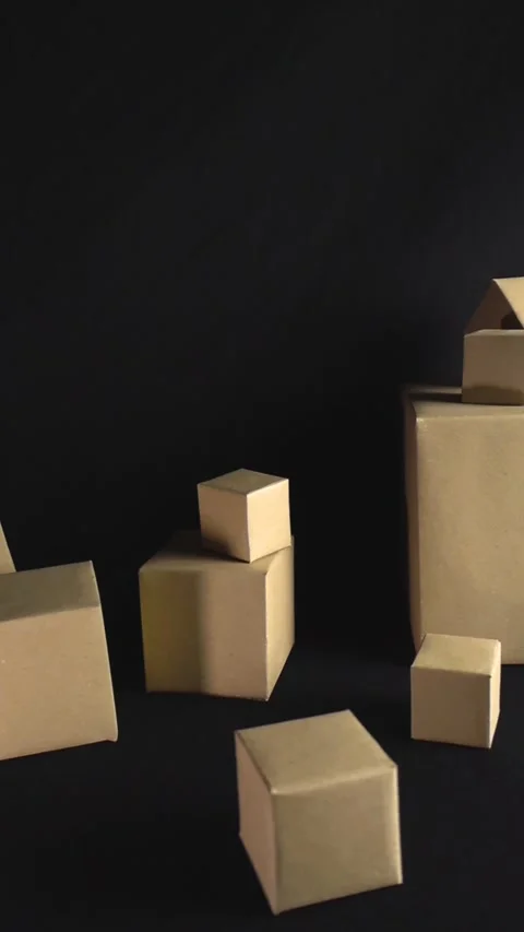 Cardboard boxes of various sizes moving on a dark background Video stock 341327370