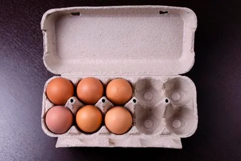 Cardboard egg box with six brown eggs Stock Photos