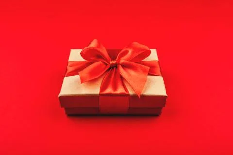 Cardboard gift box with bow on red background. Stock Photos