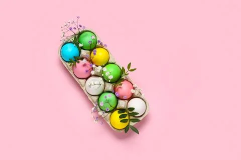 Cardboard holder with painted Easter eggs, leaves and gypsophila flowers on p Stock Photos