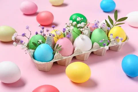 Cardboard holder with painted Easter eggs, leaves and gypsophila flowers on p Stock Photos