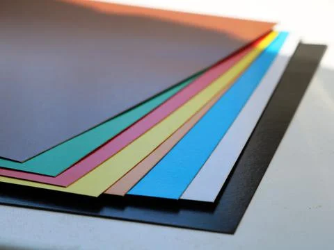 Cardboard multicolor sheets on white table Stock Photos