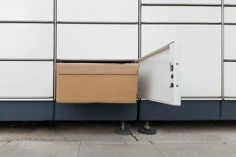 Cardboard Package in Open Parcel Locker Compartment Stockfoto's