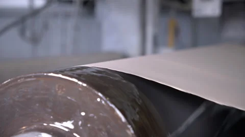 Cardboard web moves through machine of surface leveling Stock Footage 303104536