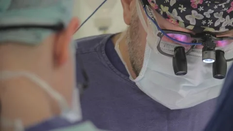 The cardiac surgeon performs the operation. Binocular surgical loupes. Stock Footage 137216535