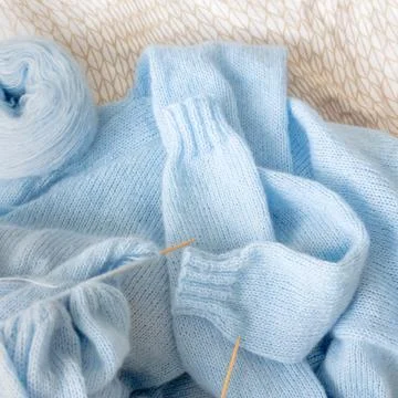 Cardigan from blue wool with the process of mating Stock Photos
