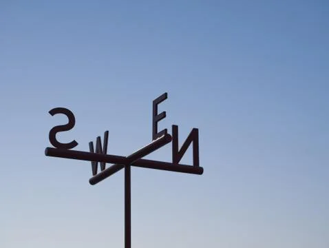 Cardinal Direction (Direction pointer) Sign against blue sky Foto stock