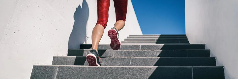 Cardio runner woman going up step of stairs at outdoor staircase for uphill hiit Stock Photos