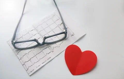 Cardiogram chart with glasses and red heart on table closeup. Cardiovascular  Stock Photos