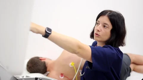 Cardiologist explaining results while performing an echocardiogram to a man Stock Footage 260758539