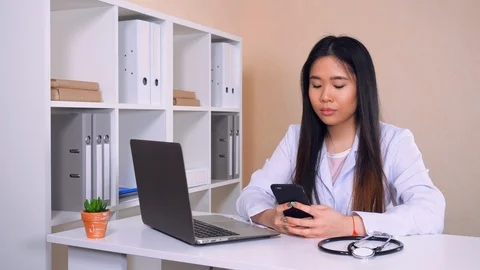 Cardiologist messaging with friend use mobile Stock Footage 88335117