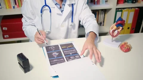Cardiologist sitting at the table and explain the disease in hospital 스톡 동영상 251941067
