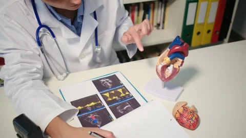 Cardiologist sitting at the table and explain the disease in hospital Stock Footage 251941101