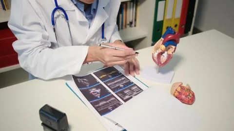 Cardiologist sitting at the table and explain the disease in hospital Stock Footage 251941128