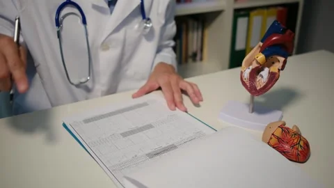 Cardiologist sitting at the table and explain the disease in hospital Stock Footage 251941153