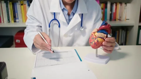Cardiologist sitting at the table and explain the disease in hospital Stock Footage 251941231