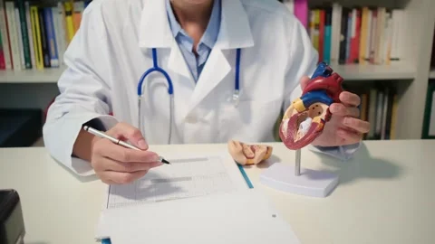 Cardiologist sitting at the table and explain the disease in hospital Stock Footage 251941253