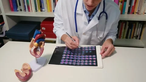 Cardiologist sitting at the table and explain the disease in hospital Stock Footage 251941313