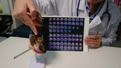 Cardiologist sitting at the table and explain the disease in hospital Stock Footage 251941314