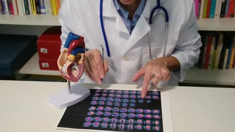Cardiologist sitting at the table and explain the disease in hospital Stock Footage 251941325