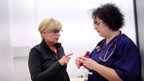 Cardiologist using a heart model to explain problems to patient Stock Footage 260758816