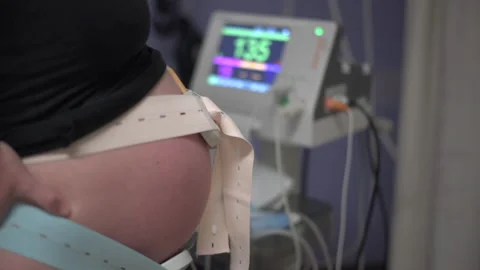 Cardiotocograph machine monitors baby heartbeat in hospital pregnant women Stock Footage