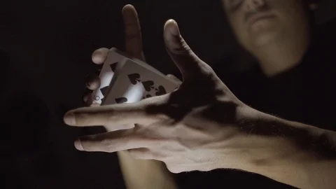 Cards fly from one hand to another. The magician shows a card trick. Slow motion Video stock 89581341
