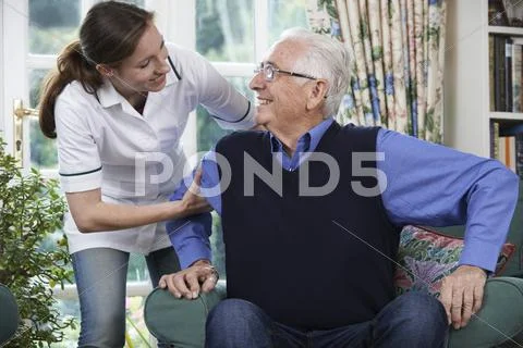 Care Worker Helping Senior Man To Get Up Out Of Chair Stock Photos