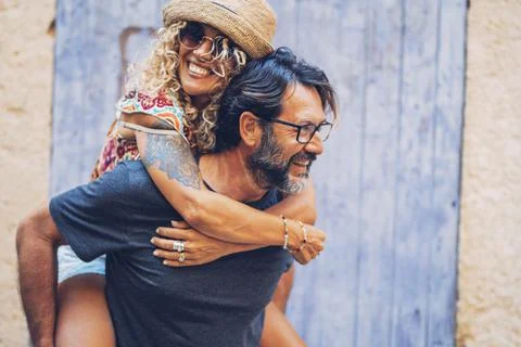 Carefree couple spending leisure time together outdoors, man giving piggyback Stock-Fotos